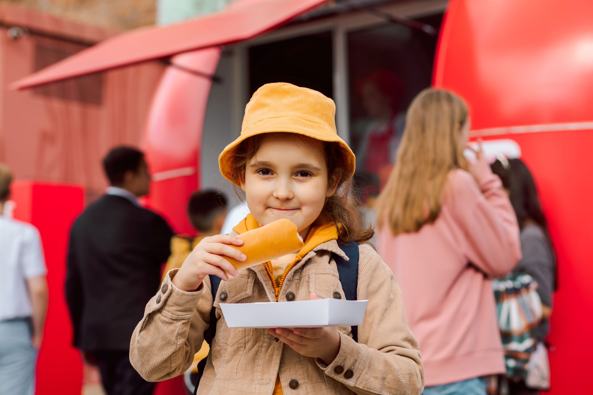 cute-little-girl-eating-hot-dog-nearby-food-track-2024-12-06-03-37-13-utc.jpg
